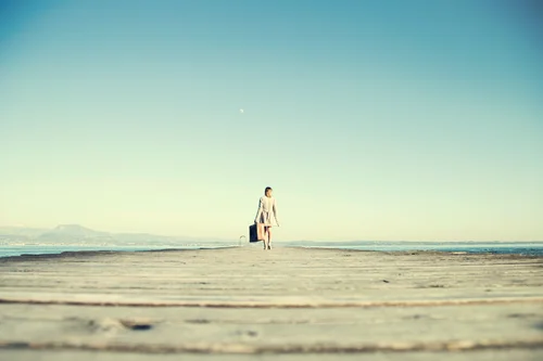 A woman walking with a suitcase